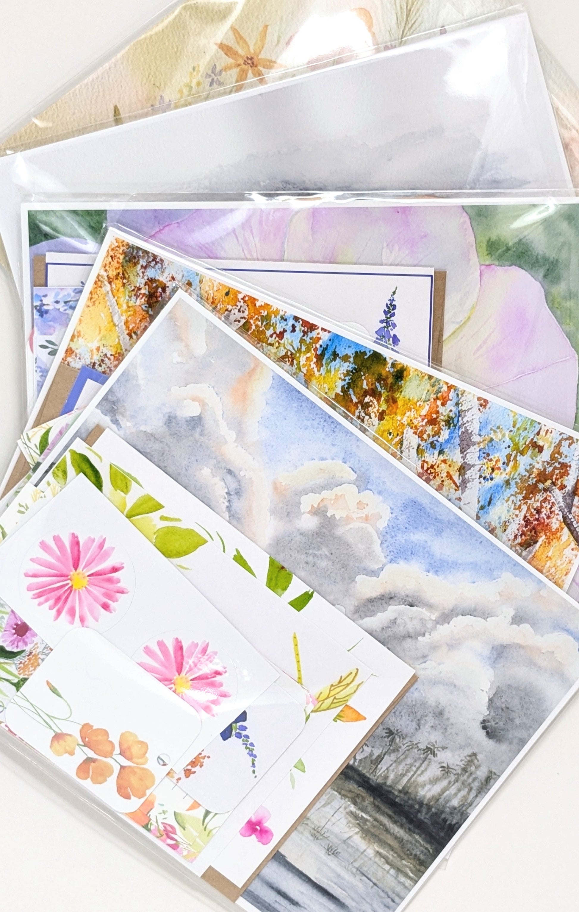 A grab bag of scenic and floral prints and stationery on a white surface.