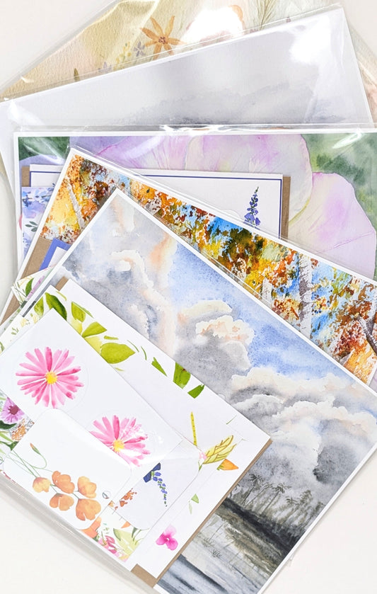 A grab bag of scenic and floral prints and stationery on a white surface.